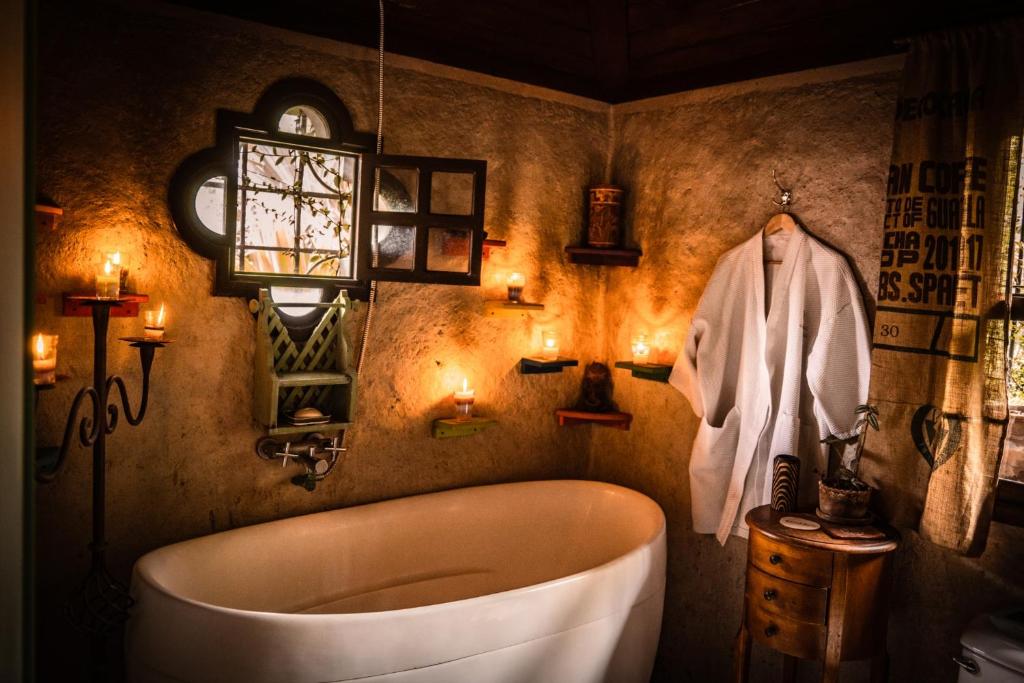 危地马拉安地瓜Baraka Antigua的带浴缸、浴袍和灯的浴室。