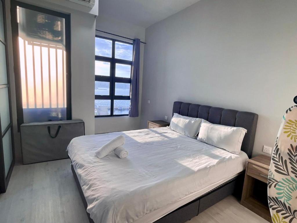哥打京那巴鲁SUNRISE JESSELTON QUAY NEAR SURIA GAYA STREET Jesselton Point的卧室配有一张带白色床单和枕头的大床。