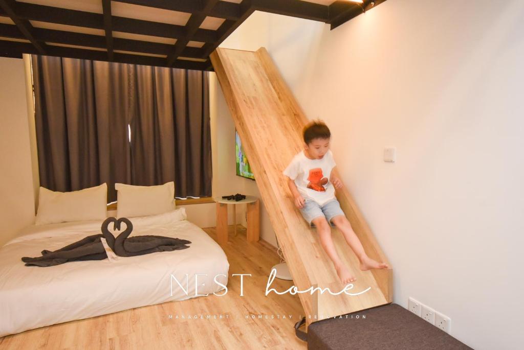 Kampong PendasSunway Grid Loft Suite by Nest Home【Olympic Size Pool】的坐在卧室梯子上的男孩