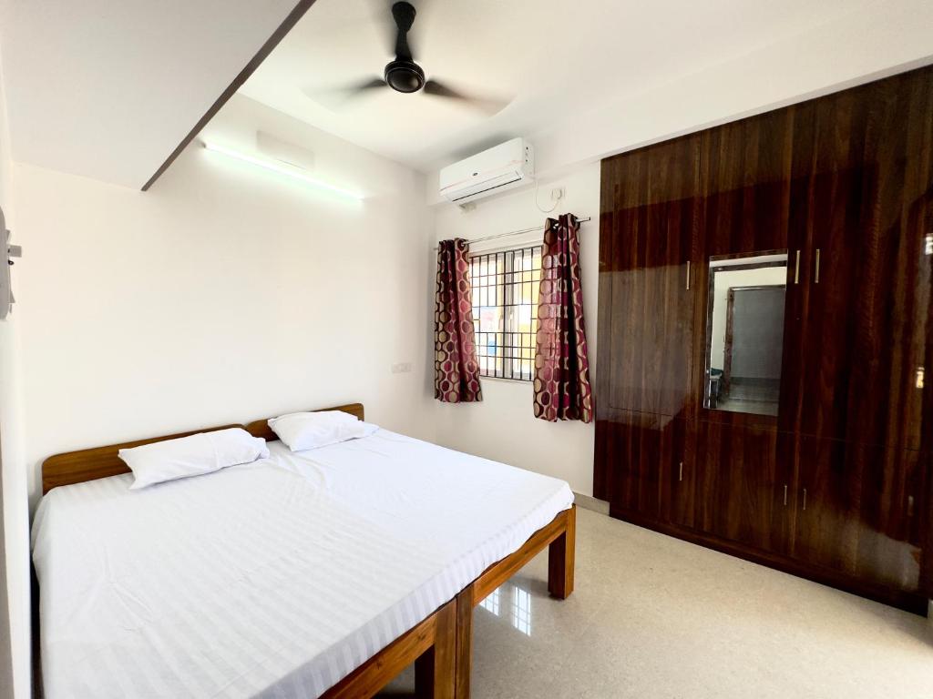 钦奈Sishya Service Apartment- 1bhk, IT Expressway, Thoraipakkam, OMR, chennai的卧室配有白色的床和镜子