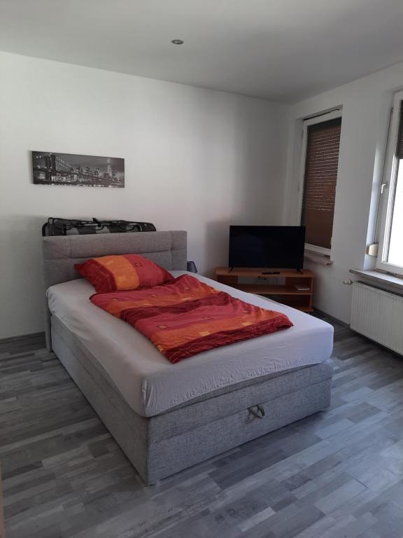 黑尔姆施泰特Gästehaus-City的一间卧室配有一张床和一台平面电视