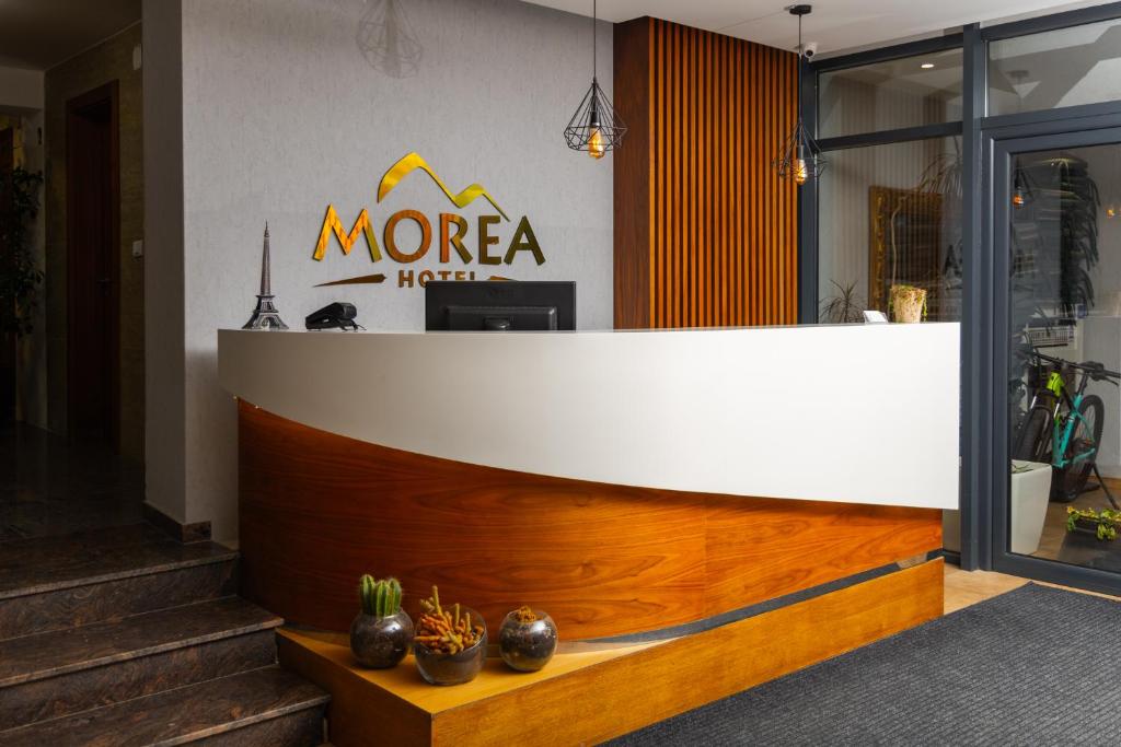 普里兹伦Morea Hotel的更宽敞的酒店大堂设有白色和木制柜台