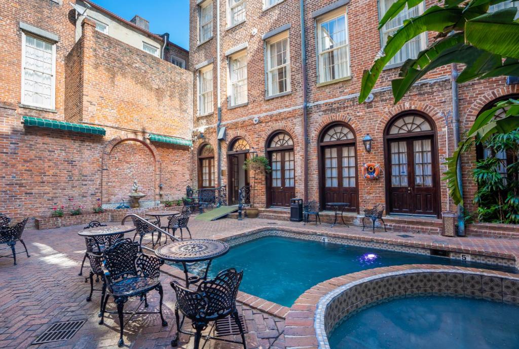 新奥尔良Quarter House Suites的庭院设有游泳池和桌椅