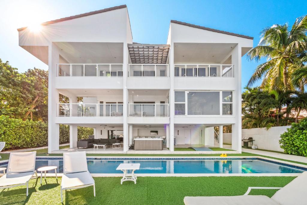 迈阿密Experience Opulence Your Exclusive Waterfront Sanctuary in Miami Beach的享有带游泳池的大型白色房屋的外部景色