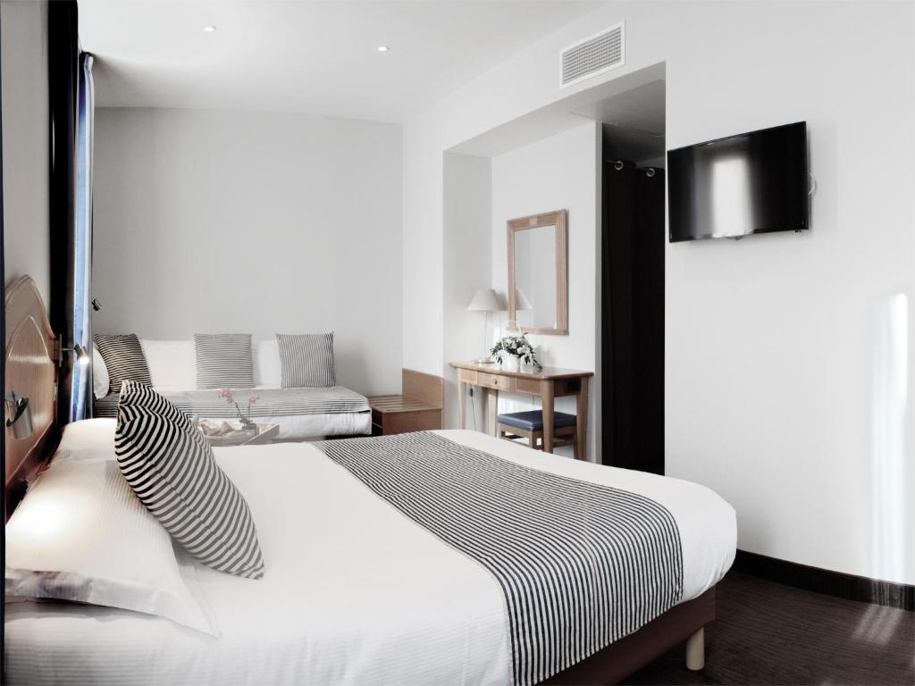尼斯蓝色精神酒店的卧室配有白色大床和黑白色枕头