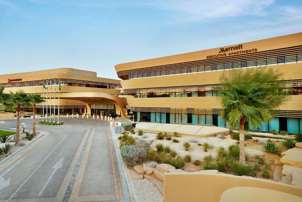 利雅德Marriott Riyadh Diplomatic Quarter的享有酒店前方棕榈树建筑的景致