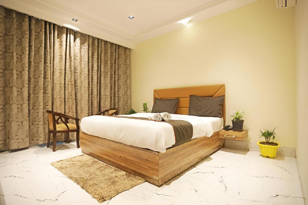 新德里Hotel GOOD LUCK HOUSE Near Delhi Airport的一间卧室配有一张大床和一把椅子