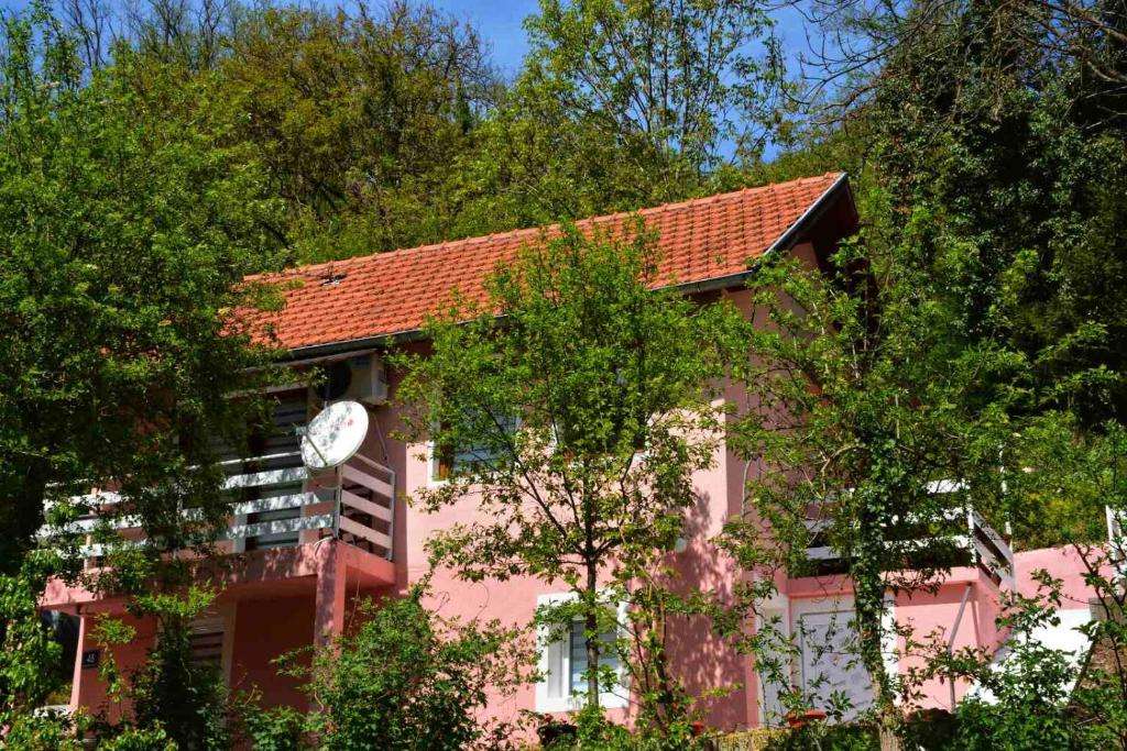 维舍格勒Dodir prirode的粉红色的建筑,旁边有一个钟