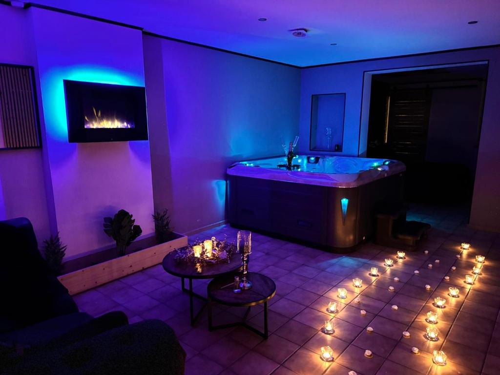 Flémalle-GrandeLes bulles d'or的紫色客房配有浴缸和桌子