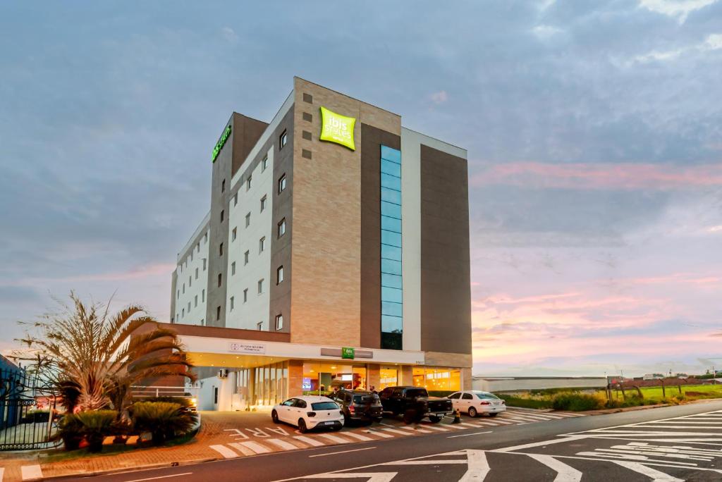 普雷图河畔圣若泽ibis Styles Sao Jose do Rio Preto的停车场内有车辆的旅馆