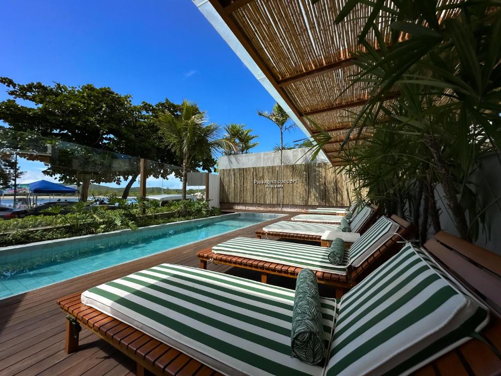 卡波布里奥Passagem Concept Hotel e Spa的游泳池旁的一排躺椅