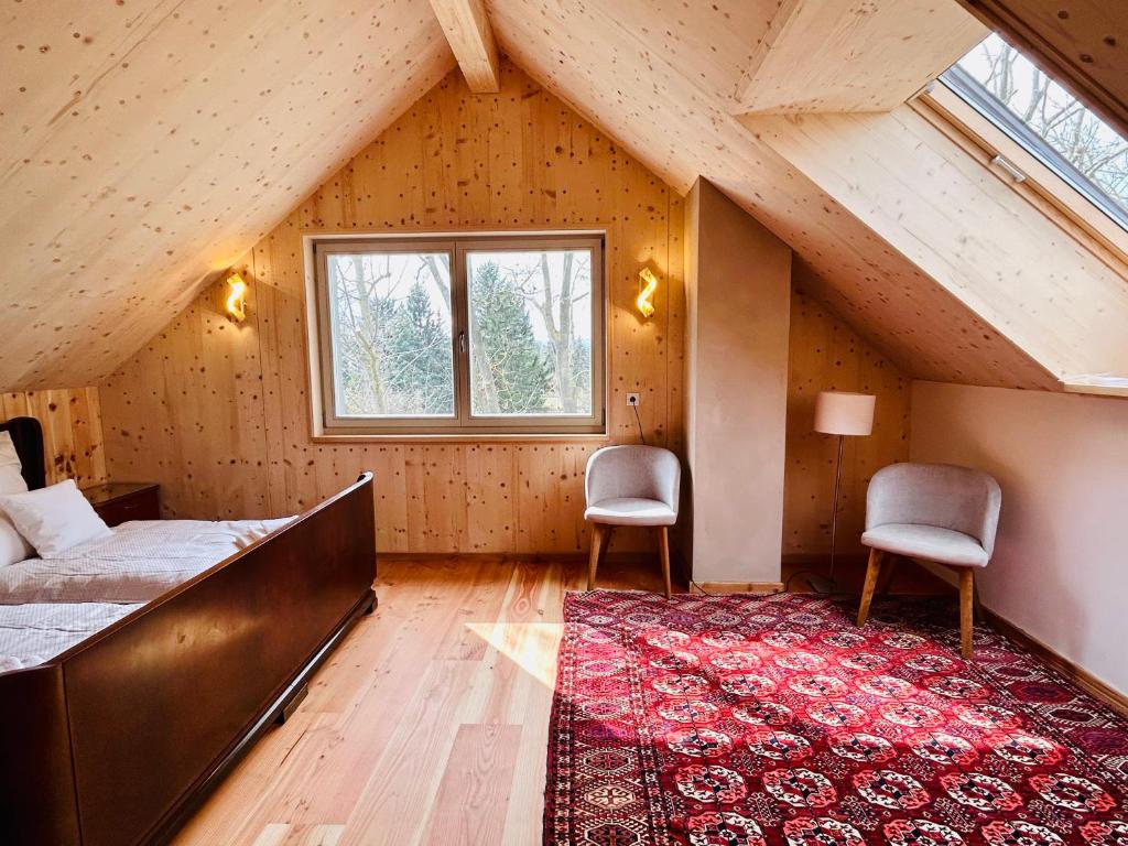 哥达Holz100-Musterhaus Gotha的一间卧室配有一张床、两把椅子和一个窗户