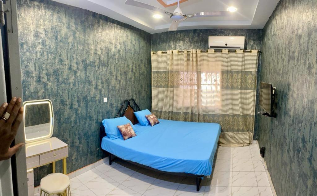 瓦加杜古Seïf Industry's的一间位于客房内的蓝色床卧室