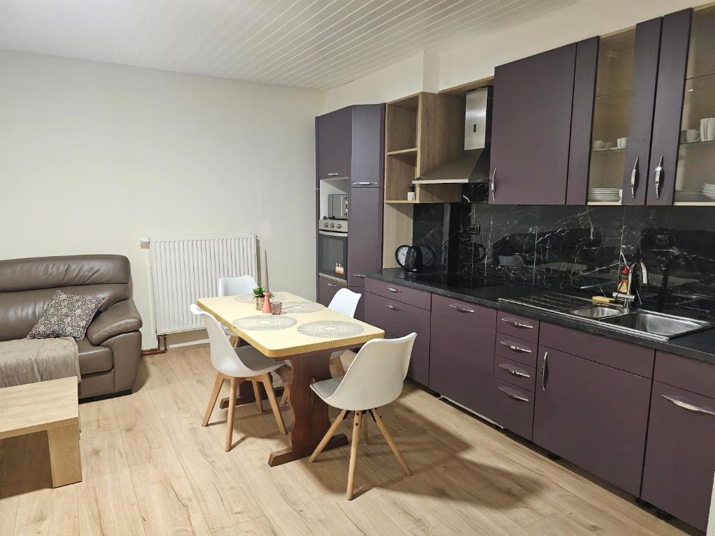 盖伦基兴Neu Modernisiert Work and Stay top moderne 3 Zimmer Wohnung 5 Betten的厨房配有紫色橱柜和桌椅