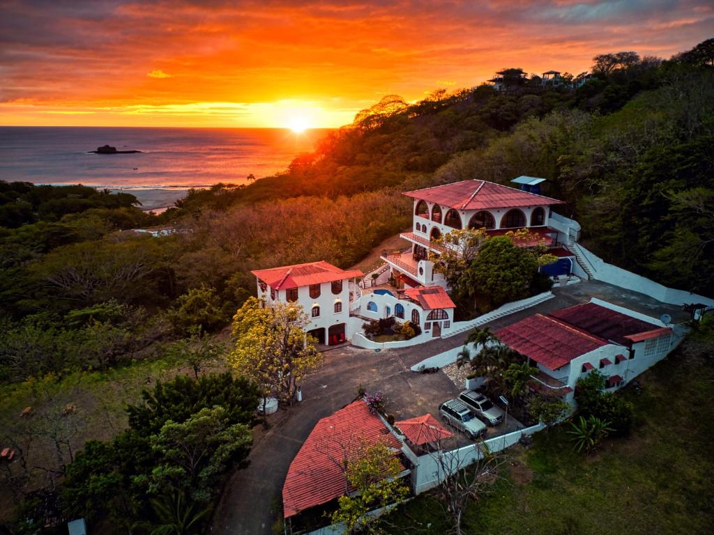 南圣胡安Beachside stay at Villa ViYarte的享有房子的空中景色,背景是日落