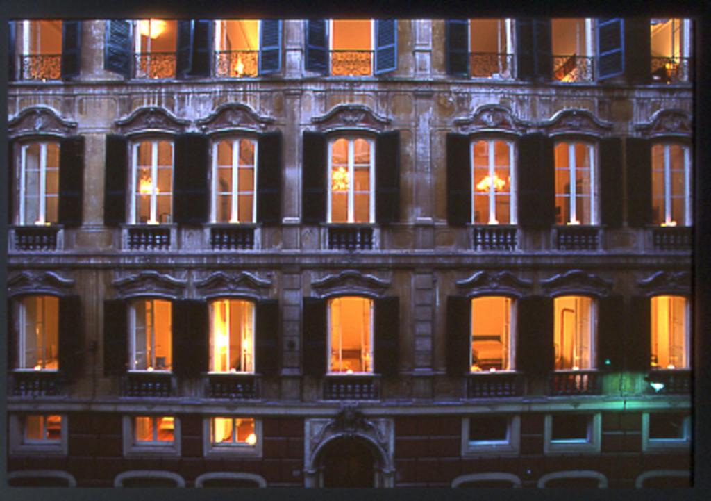 热那亚Palazzo Cicala的一座高大的建筑,晚上有窗户照亮