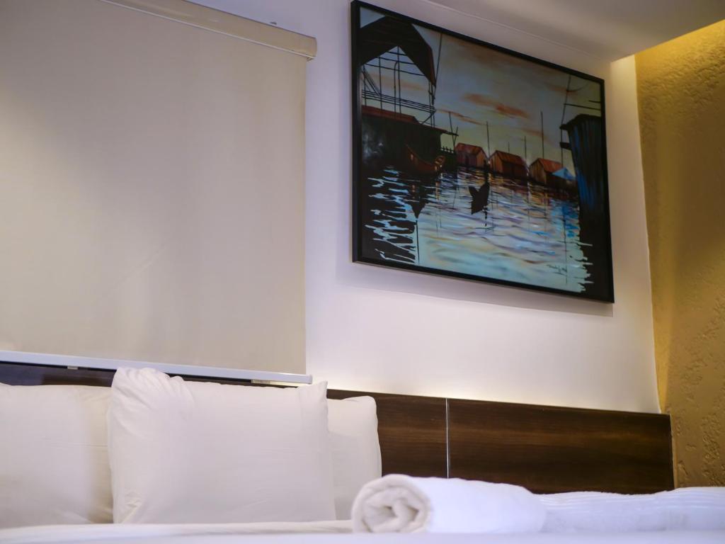 拉各斯Oliver Twist Hotel的酒店客房的墙上设有一张带绘画的床铺。