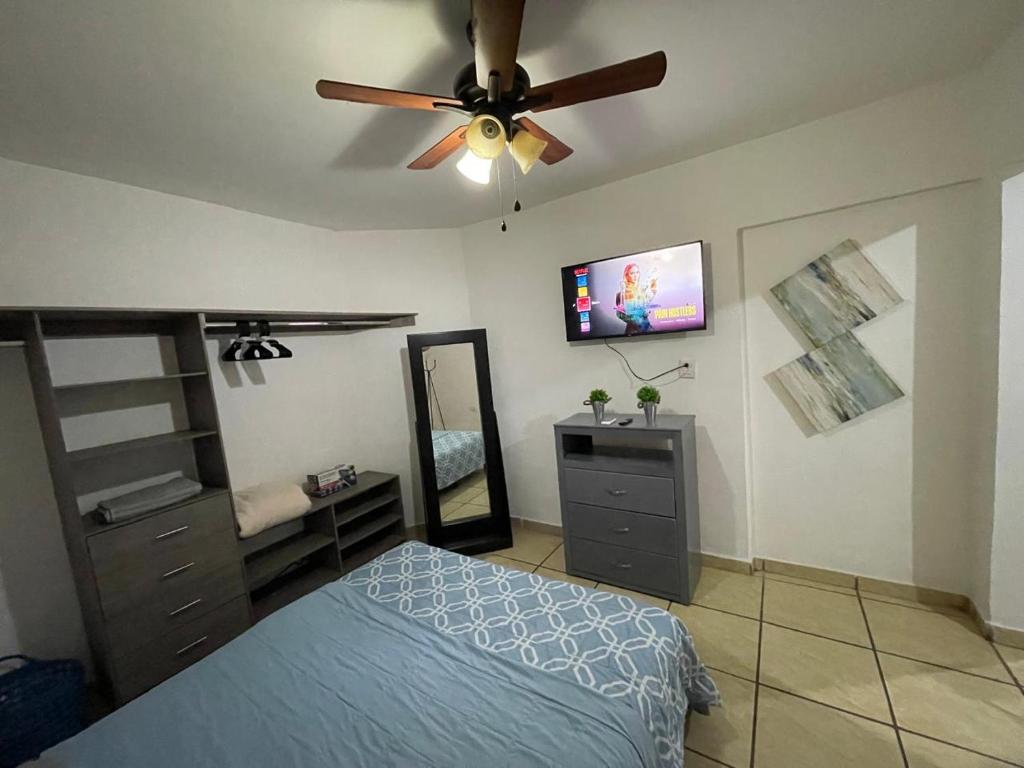 埃莫西约Cozy studio apartment located in commercial area的一间卧室配有一张床和吊扇