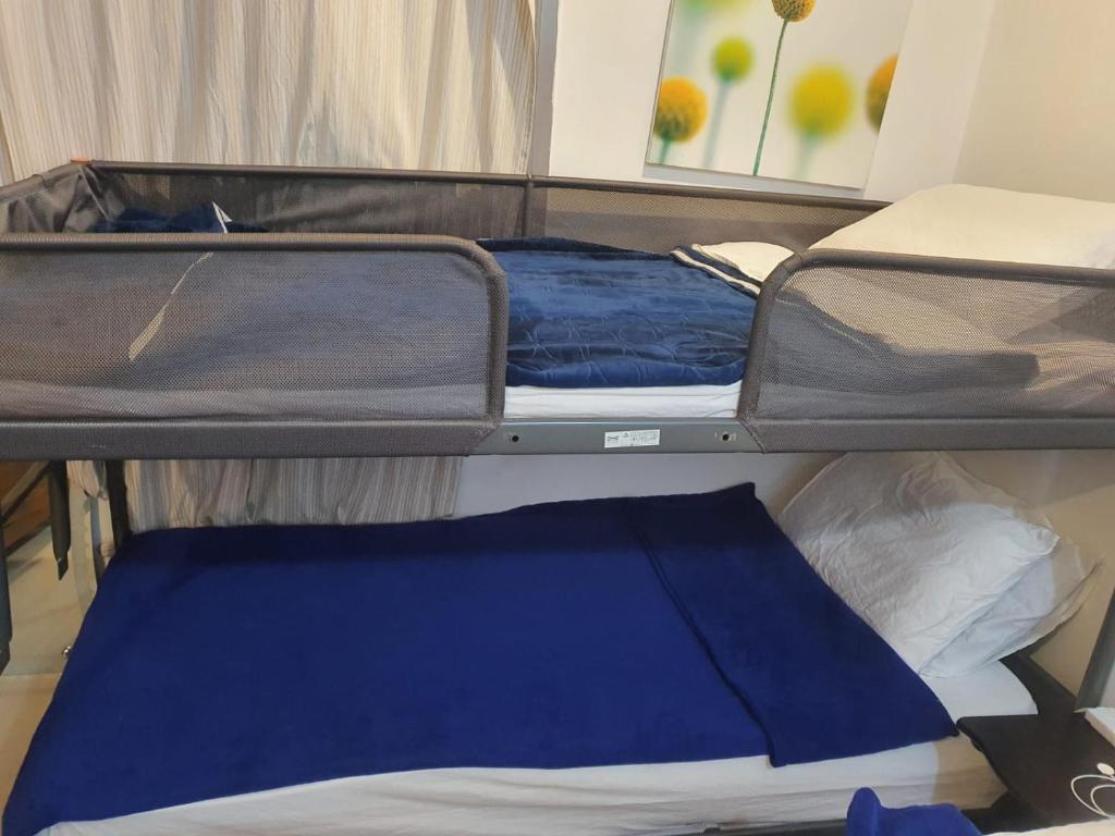 科威特Amina hostel for backpackers的一张带蓝色床单的开放式双层床