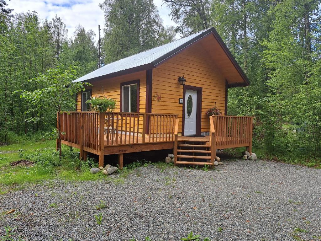 塔尔基特纳Talkeetna Fireweed cabin 2的小木屋设有大甲板和门廊