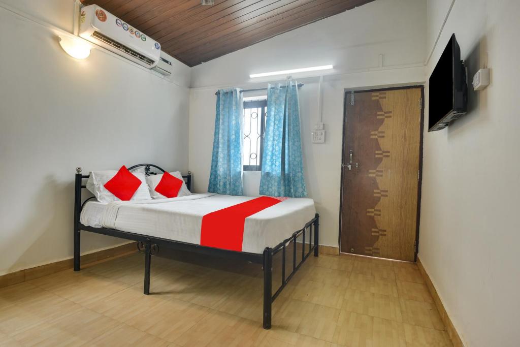 巴加OYO Pratisha Guest House的一间小卧室,配有一张床和电视