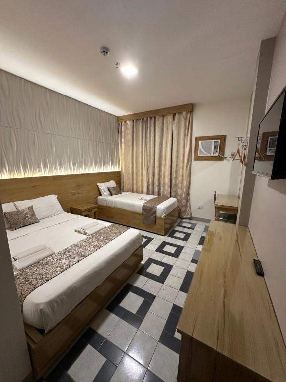 第波罗Bamboo Garden Bussiness Inn的酒店客房设有两张床和窗户。