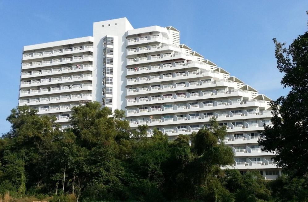 班佩罗勇公寓的一座高大的白色建筑,前面有树木