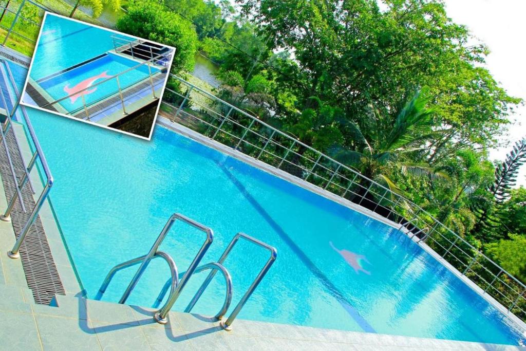 BandaragamaRiver Top Holiday Resort的围栏旁的大型蓝色游泳池