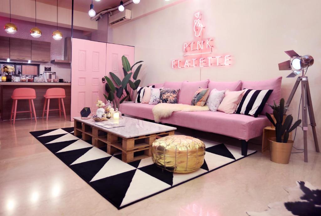 台南二館民宿的客厅配有粉红色的沙发和桌子