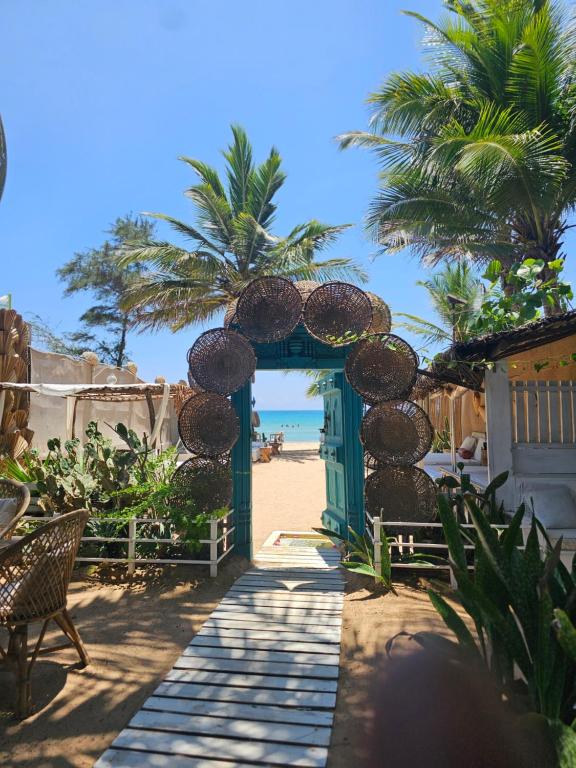 尼拉瓦利Memo's Beach的海滩入口,拥有绿门和棕榈树