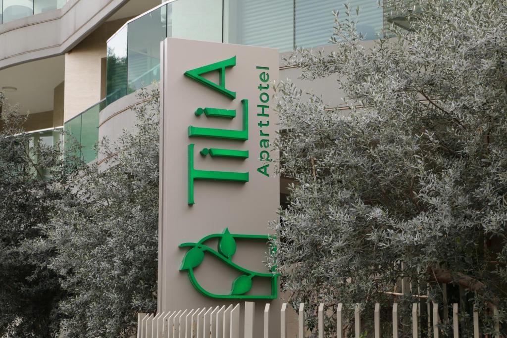 贝鲁特Tilia Hotel Beirut的树木丛生的建筑前的标志