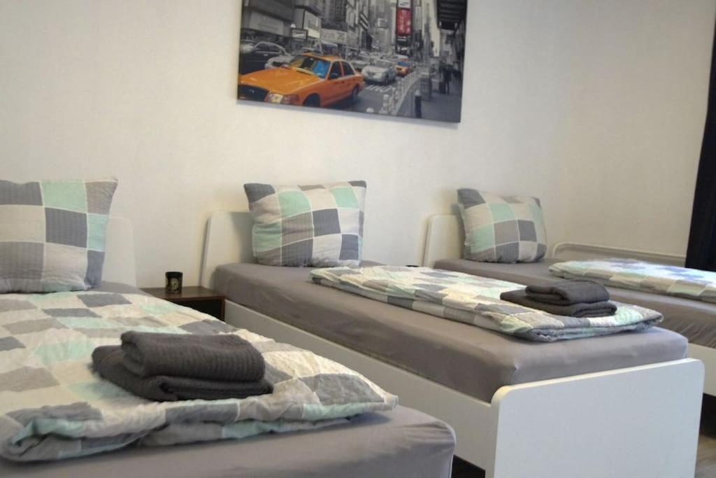 奥伯豪森Maye Oberhausen City Deluxe 3的墙上有一辆汽车,房间内设有两张床