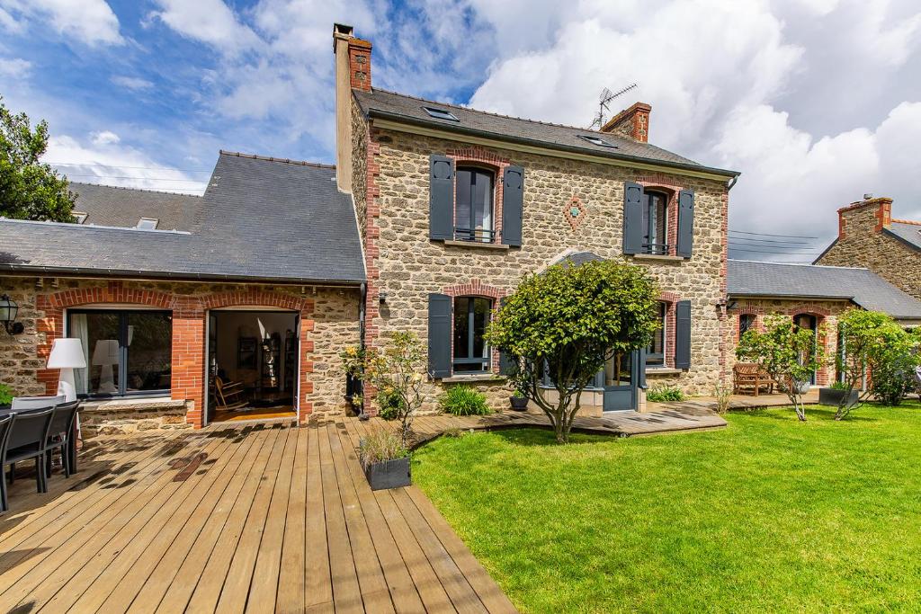 迪纳尔CLOS HILY - Maison d'exception à Dinard - 10 pers的庭院中带木甲板的房子