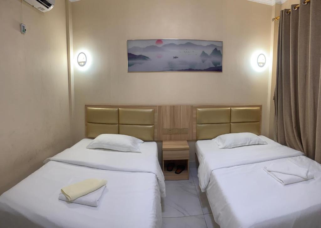西哈努克西港宾馆的小型客房的两张床,配有两把水电马桶