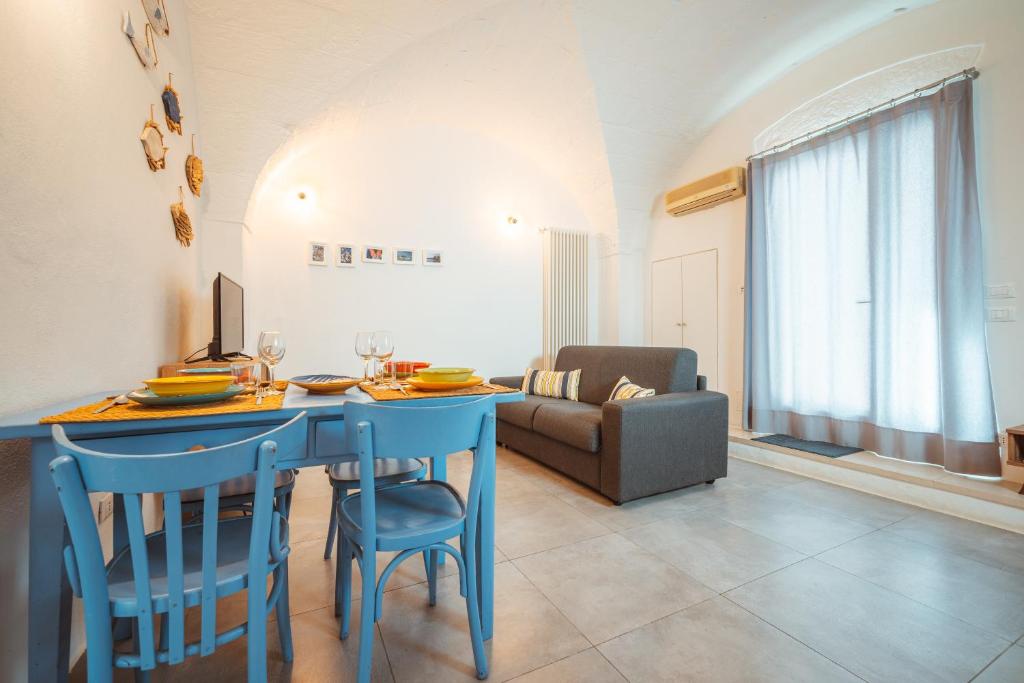 滨海波利尼亚诺Poseidonia-Housea Travel的客厅配有蓝色的桌子和椅子