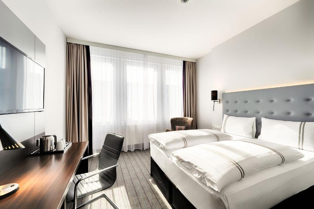 慕尼黑Premier Inn München City Ost的酒店客房设有一张大床和一张书桌。