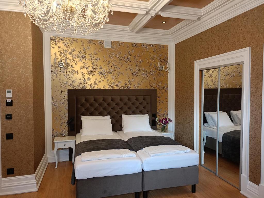 奥古斯图Oficerski Yacht Club的一间卧室配有两张床和吊灯。