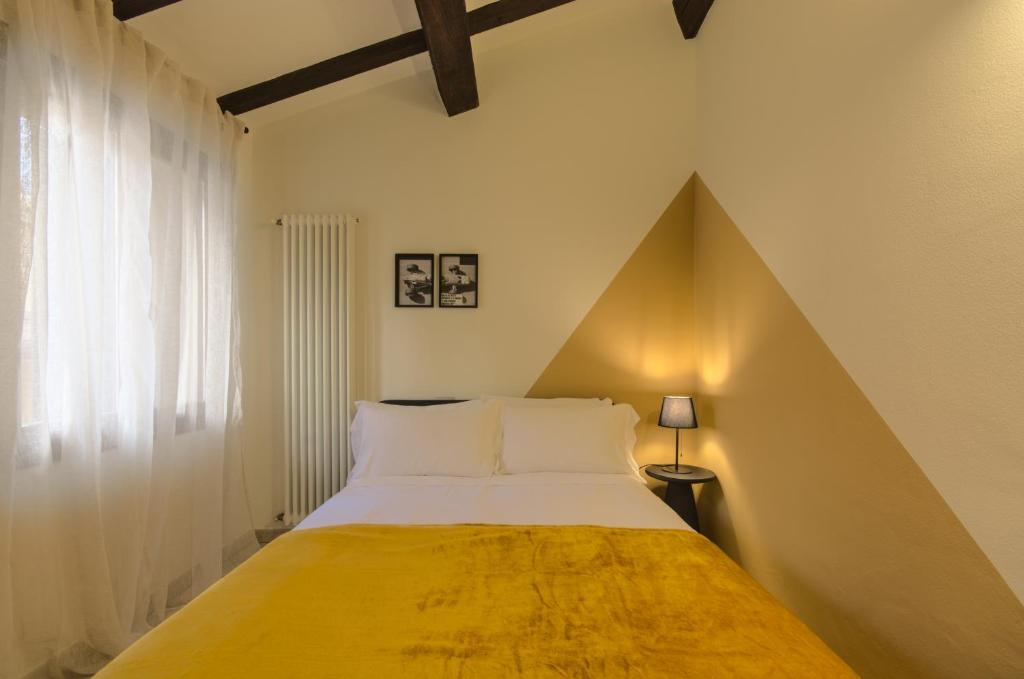 伊莫拉Imola Residence - Self Check-in的一间卧室配有一张带黄色毯子的大床