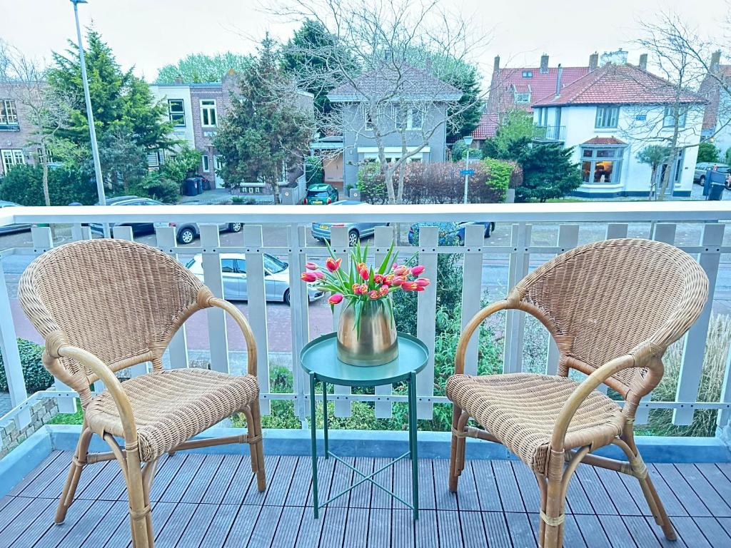 赞德沃特Lovely Spacious Apartment的阳台上配有两把椅子和一张带鲜花的桌子