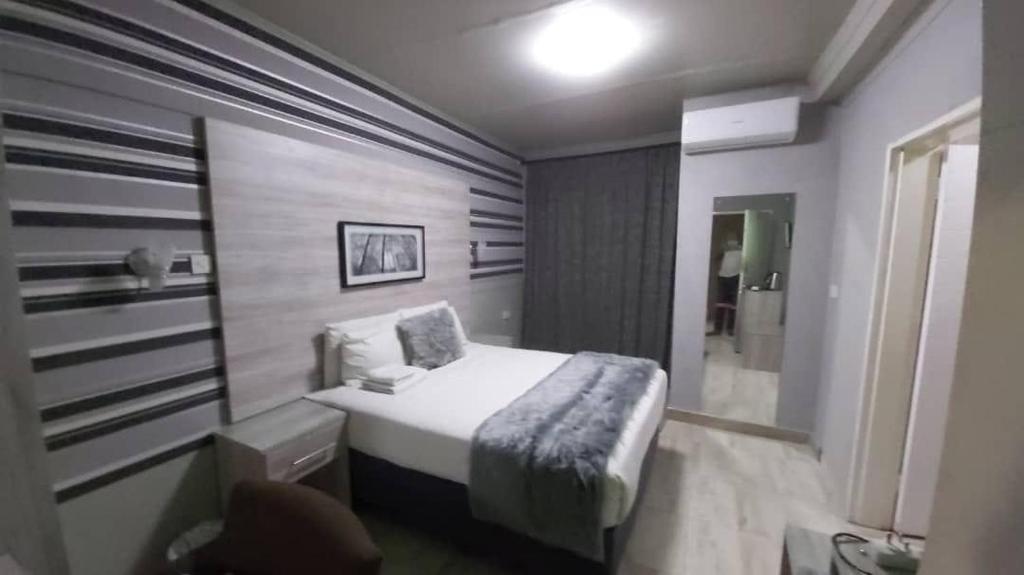 马翁Luxe Haven Suites的一间小卧室,卧室内配有一张床铺