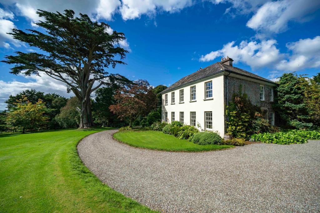 KilbrittainLarge country house close to the sea in West Cork的白色房子,有碎石车道