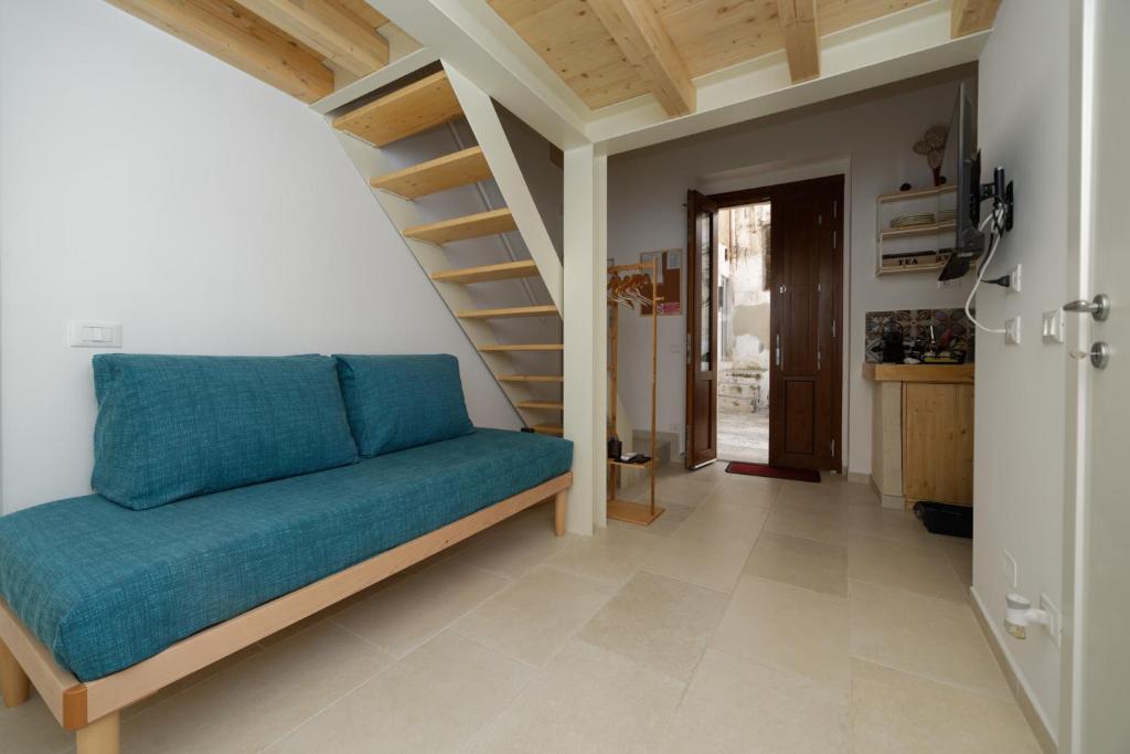 格罗塔列Casa Vacanze Ranieri的客厅设有蓝色的沙发和楼梯。