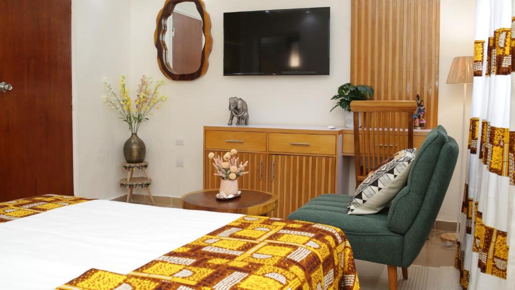 阿比让马尔利酒店的酒店的客房 - 带一张床、椅子和电视