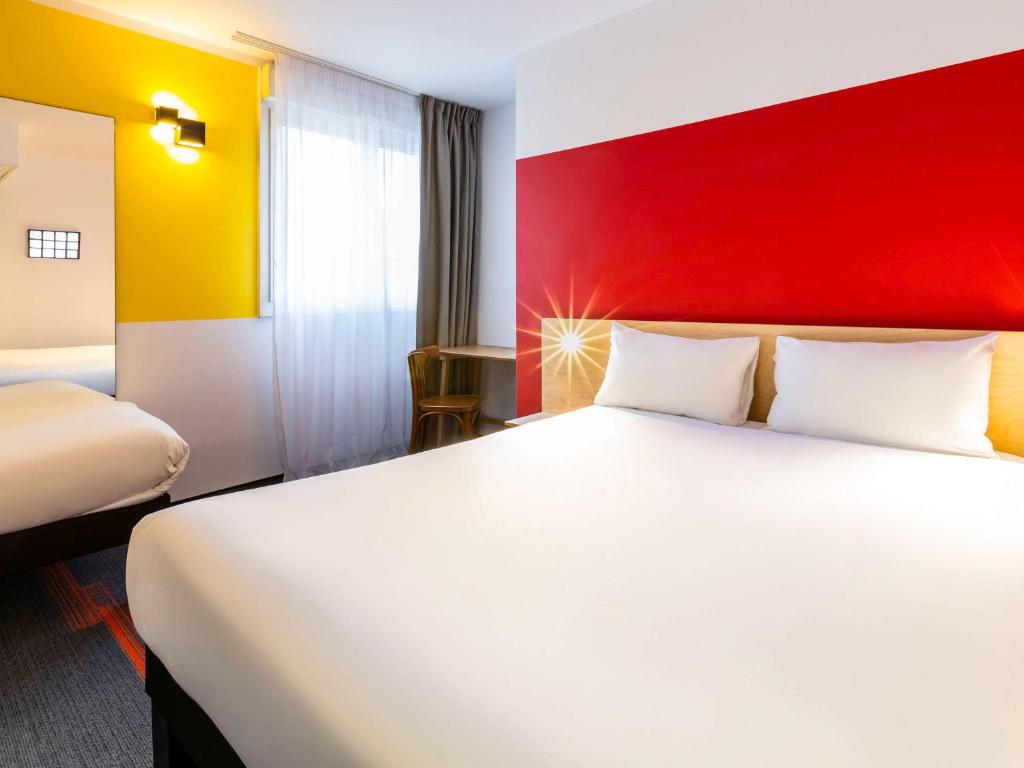 乌德蒙greet Hotel Nancy Sud的酒店客房,设有白色的床和红色的墙壁