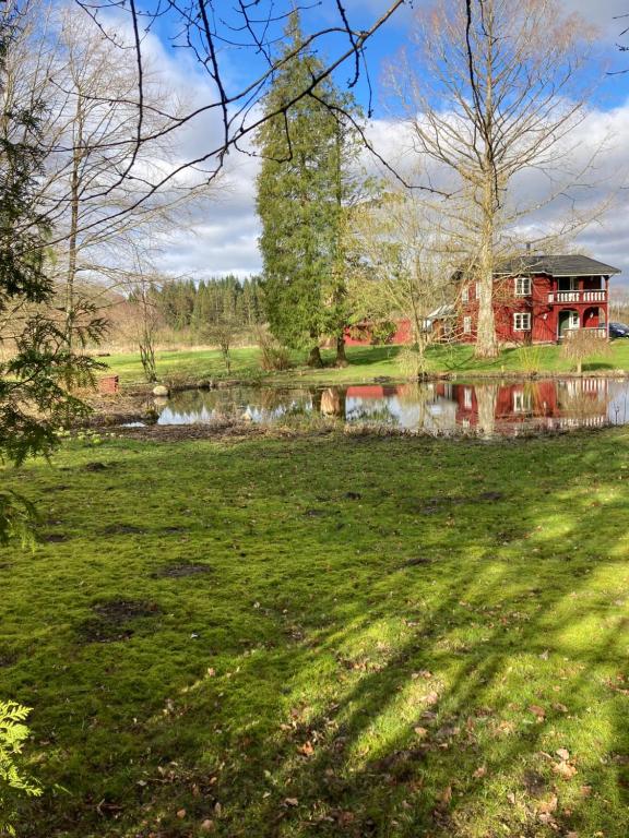 灵斯泰兹BNB Schweizerhuset的田间中带池塘的房子