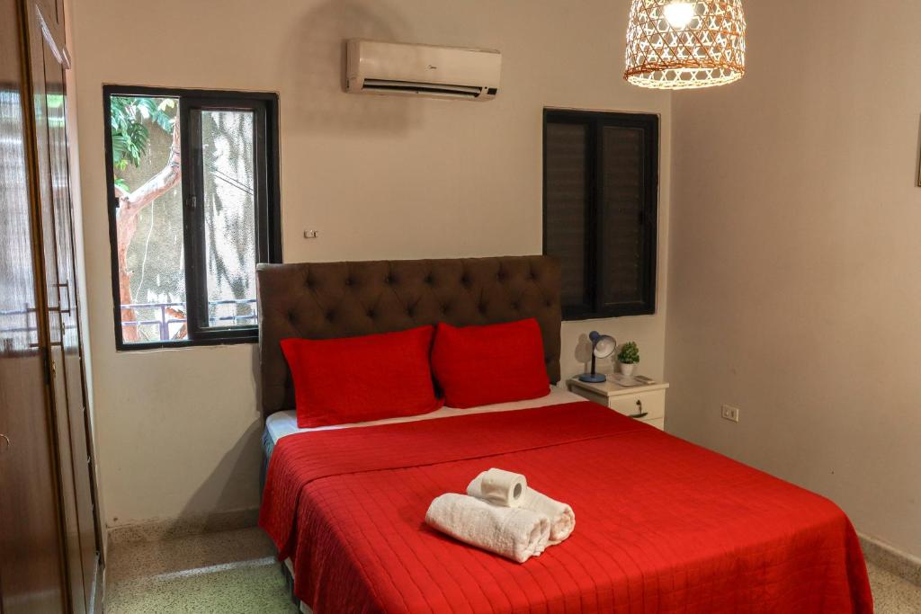 亚松森Renty Paraguay的一间卧室配有红色的床,上面有毛巾