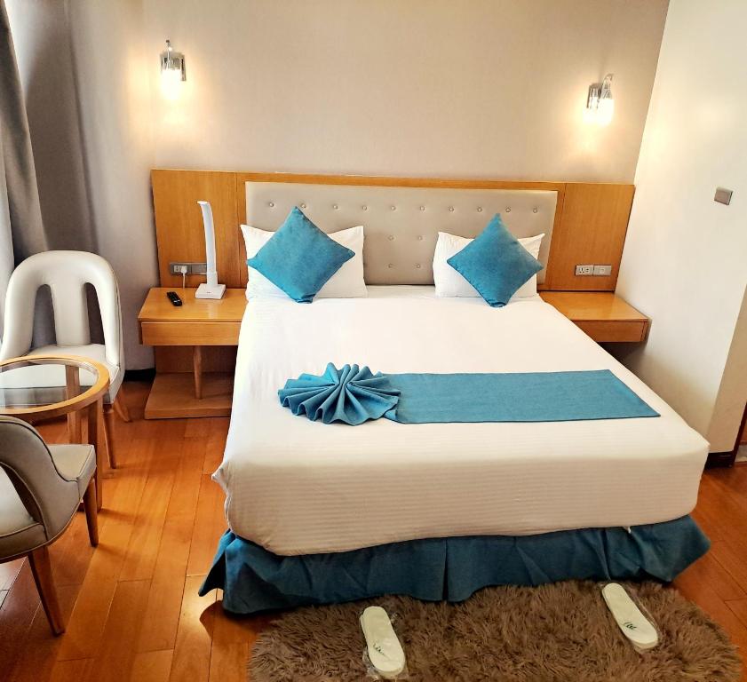 亚的斯亚贝巴Z Addis Hotel的酒店客房配有一张带蓝色枕头的大床
