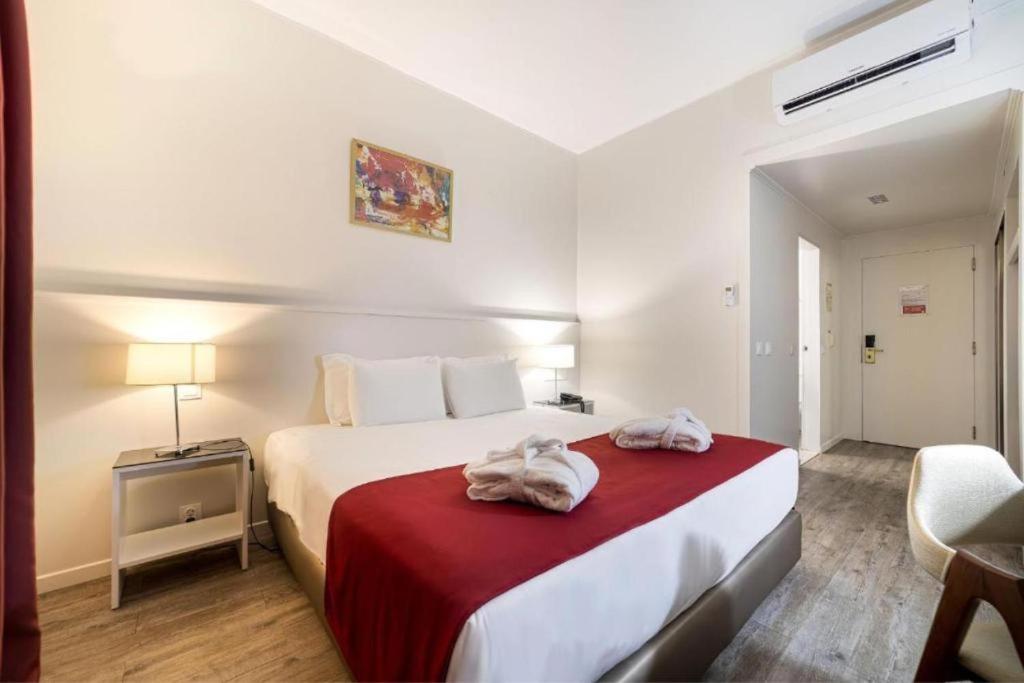 布拉加Hotel Estacão - Braga的酒店客房,配有带毛巾的床