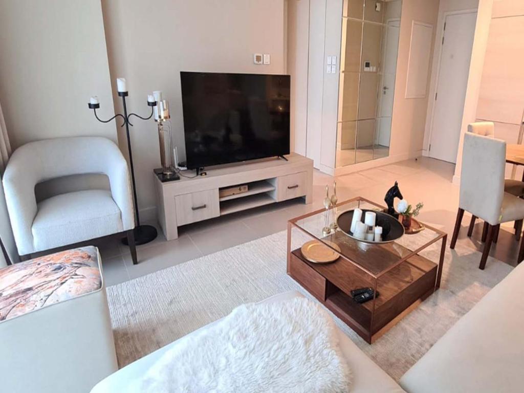 Durrat Al BahrainMarassi shores - 310的客厅配有平面电视和桌子。