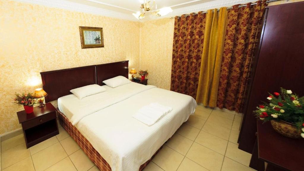 马斯喀特فندق الخليج للشقق الفندقية GULF HOTEL APARTMENTS的卧室配有一张白色大床